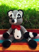 Szop w czerwonej muszce - maskotka robiona na szydełku