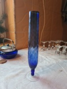 Wazon z niebieskiego szkła na nóżce. 