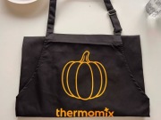 Czarny fartuch z logo Thermomix z pomarańczową dynią