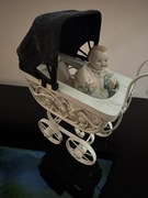 Mały wózek wiklinowy z lalka 