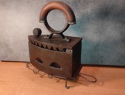 Stare żeliwne żelazko na na węgiel z podstawką