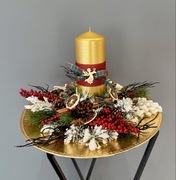 Elegancki świąteczny stroik na złotym talerzu.