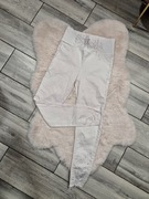 Stylowe białe spodnie z wysokim stanem ozdobione kryształkami przetarciami