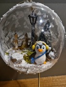 Bombka 3d przestrzenna pingwinek  przy płotku w zimowym wnętrzu 