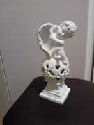 Aniołek siedzący na kuli.