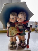 Spacerują dzieci w deszczu pod parasolem Hummel