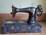 Stara maszyna do szycia Singer na dekoracyjnej podstawie 