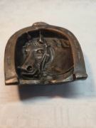 popielniczka na szczęście w kształcie podkowy z głową konia.