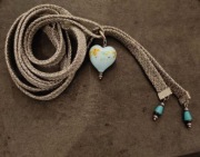 szary naszyjnik lub pasek z niebieskim szklanym sercem