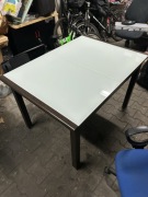 Stół z mlecznym szklanym blatem.