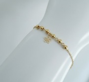 Złota bransoletka z kuleczkami i zawieszką – kwiatek