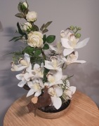 Kompozycja białych storczyków z różą, korzeniem w srebrnej doniczce