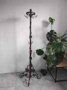 Metalowy wieszak stojący z ozdobnymi nogami, kuty