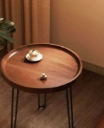 okrągły stolik kawowy z ciemnego drewna i metalowymi nogami