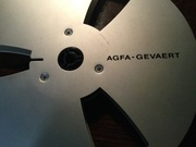 Szpula aluminiowa firmy Agfa do magnetofonu szpulowego i karton.