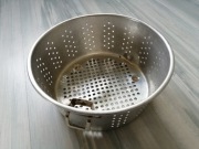 Aluminiowe sitko / durszlak / cedzak z gęsto obsianymi otworami. 