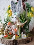 Stroik świąteczny wielkanocny na plastrze drzewa z złotymi zajączkami.