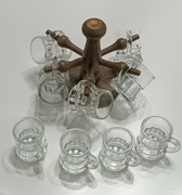 Zestaw kieliszków na drewnianym stojaku.