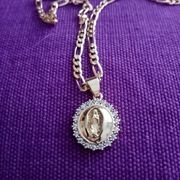 Łańcuszek z medalikiem z wizerunkiem MB z Gwadelupe w kolorze złotym. 