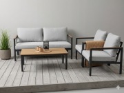 Zestaw ogrodowy sofa dwa fitele stolik z drewnianym blatem.