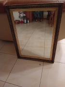 Lustro wiszące w klasycznej złoconej ramie.