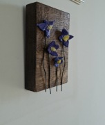 Fioletowe kwiatki z gliny na dębowej desce - rękodzieło 