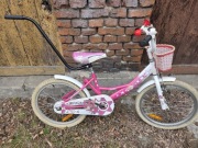 Różowy rower dla dziewczynki Koła 20 z koszykiem i drążkiem do nauki.