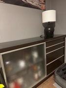 Czarna komoda z szufladami, szklany blat.