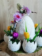 Dekoracja, stroik wiosenno  wielkanocny na spodzie drewnianym z krokusami. 