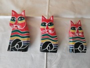 Trzy kolorowe drewniane figurki kotów z Bali
