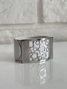 Szeroka bransoletka ze skóry i stali szlachetnej w kwiatki.