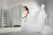 Biała suknia do sesji ciążowej z bardzo długim trenem do podrzucania
