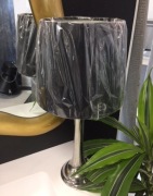 Lampa stojąca osdobn z czarnym abażurem.