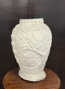 Pękaty gipsowy wazon z liśćmi dębu.