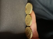 3 monety 1 funtowe, jedna z nich ma odwrócony napis na rancie