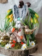 Stroik świąteczny wielkanocny na plastrze drzewa z złotymi zajączkami.