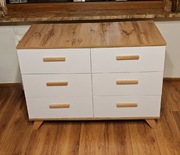 Komoda biała z szufladami.