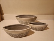 Zestaw trzech ceramicznych doniczek w kształcie łudek z kwiatowym motywem. 