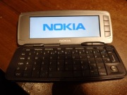 Telefon NOKIA 9300i w kolorze srebrnym ładowarka akku, brak tylnej klapki.