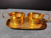 Złote metalowe koszyczki i taca na szklanki