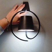 Czarny, bezprzewodowy kinkiet LED Zafferano Poldina wykonany z aluminium. 
