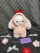 uroczy pluszak króliczek w różowej rozpinanej piżamie z czerwoną kokardą