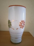 Stary biały szklany wazon z czerwonymi i zielonymi kwiatami
