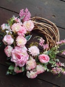 Różowy wianek z goździków i róż na drzwi grób 