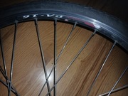 dwa koła do roweru, siodełka, łańcuch z przerzutką.