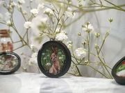 Wisiorek z obrazem króliczka malowanym odręcznie.