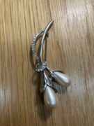 broszka kwiatek . metal kolor srebrny, oczka plastikowe  imitujące perły