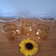 Trzy szklanki w złotych koszyczkach 
