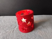 Czerwony, filcowy świecznik w kształcie walca z wyciętymi gwiazdami