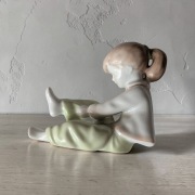 Dziewczynka zakładająca bucik porcelana Aquincum 